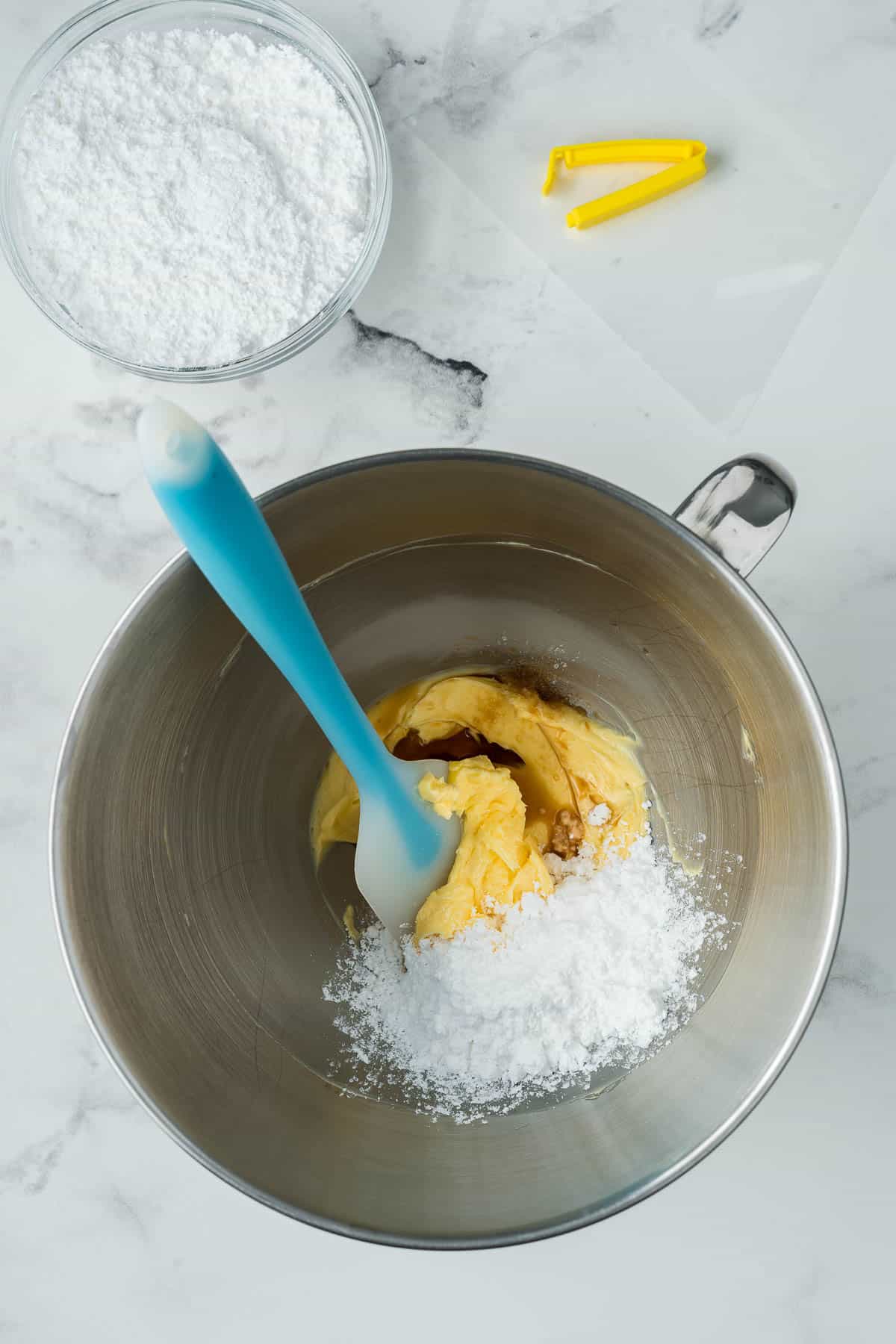 Adding powdered sugar, vanilla, and salt to make buttercream. 
