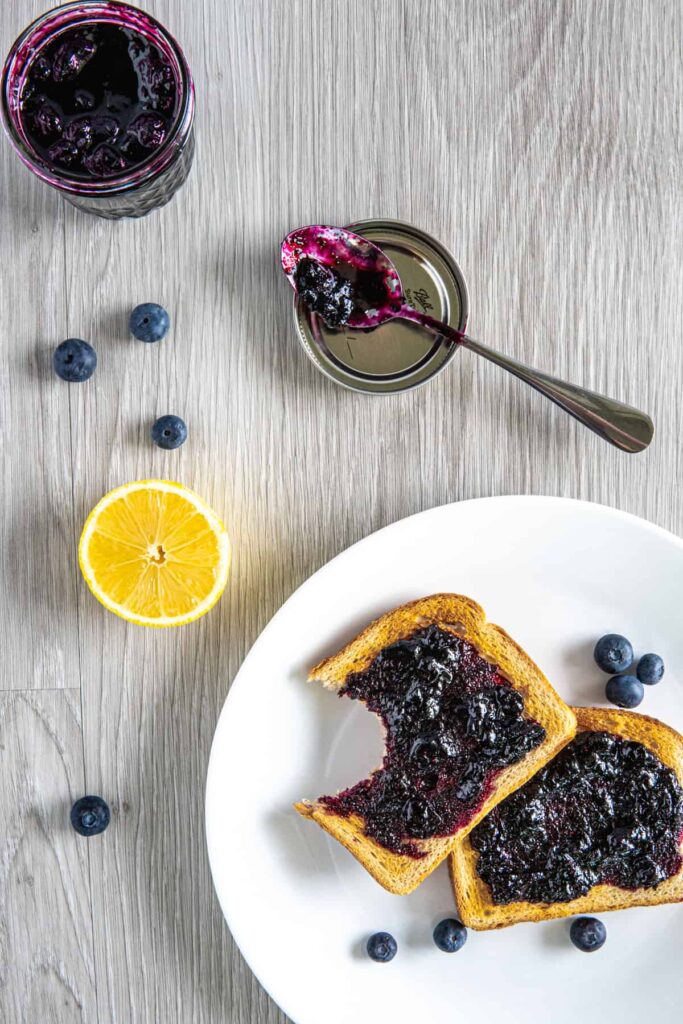 Two pieces of toast on a plate with blueberry vanilla jam.