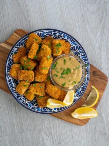 Air fryer tofu nuggets on a blue patterned plate with lemon.