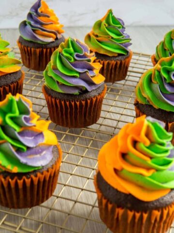 Swirled Halloween cupcakes on a wire rack.