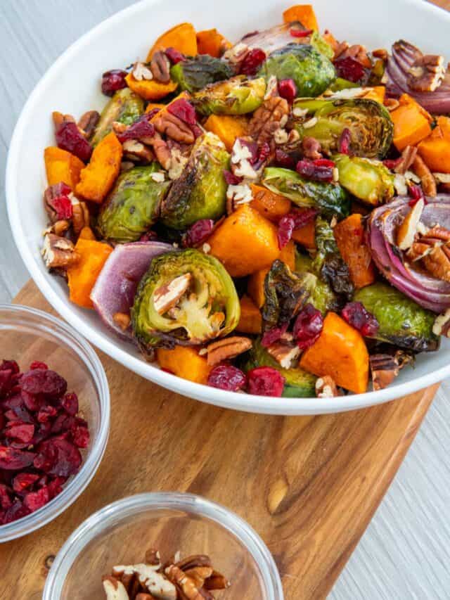 Roasted brussel sprouts sweet potatoes recipe on a wooden serving board.