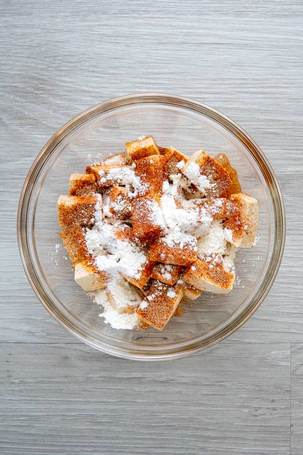 Tofu with cornstarch and spices sprinkled on top.
