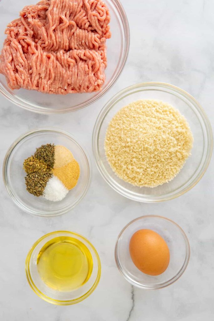 Ingredients for air fryer turkey meatballs on a white marble background.