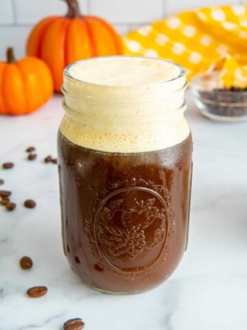 Pumpkin cold foam in a glass mason jar.