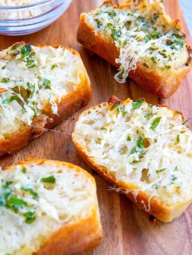 Close-up of stuffed garlic bread on a wooden board.