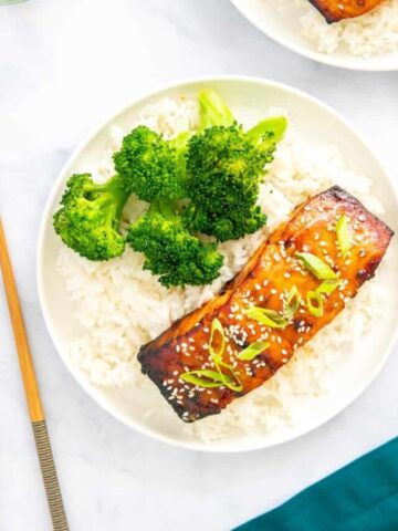 Teriyaki salmon air fryer on a white plate with broccoli and rice.