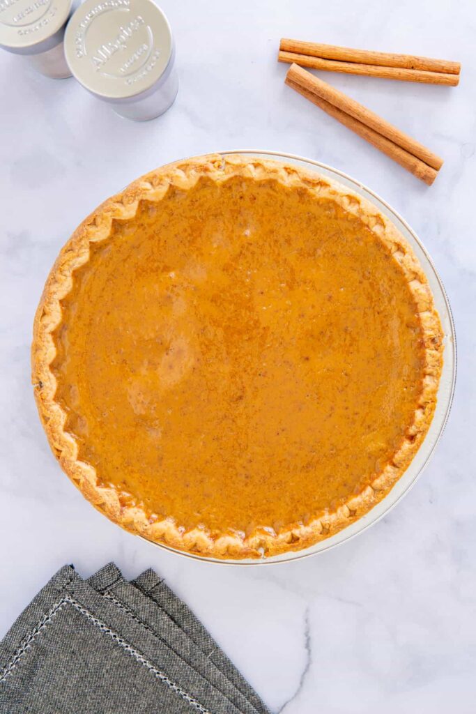 Cooked pumpkin pie without evaporated milk on a white plate.