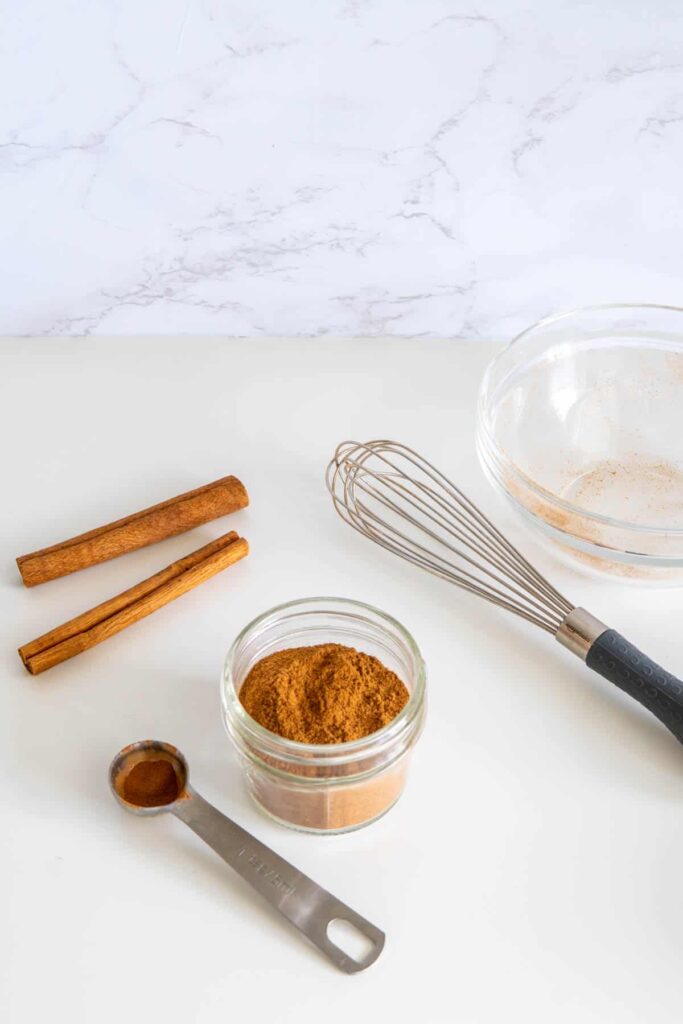 Mixed homemade pumpkin pie spice mix in a bowl with a whisk.
