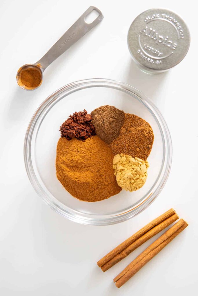 Ingredients for homemade pumpkin pie spice mix in a glass bowl.