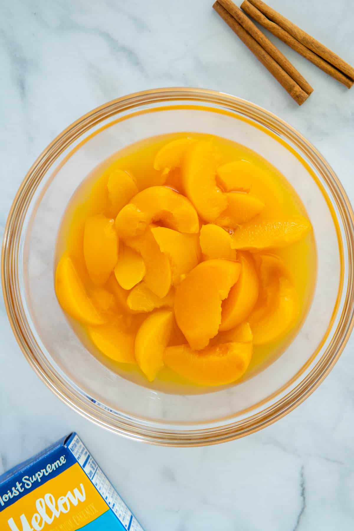 Tinned peaches in light syrup in a glass bowl. 