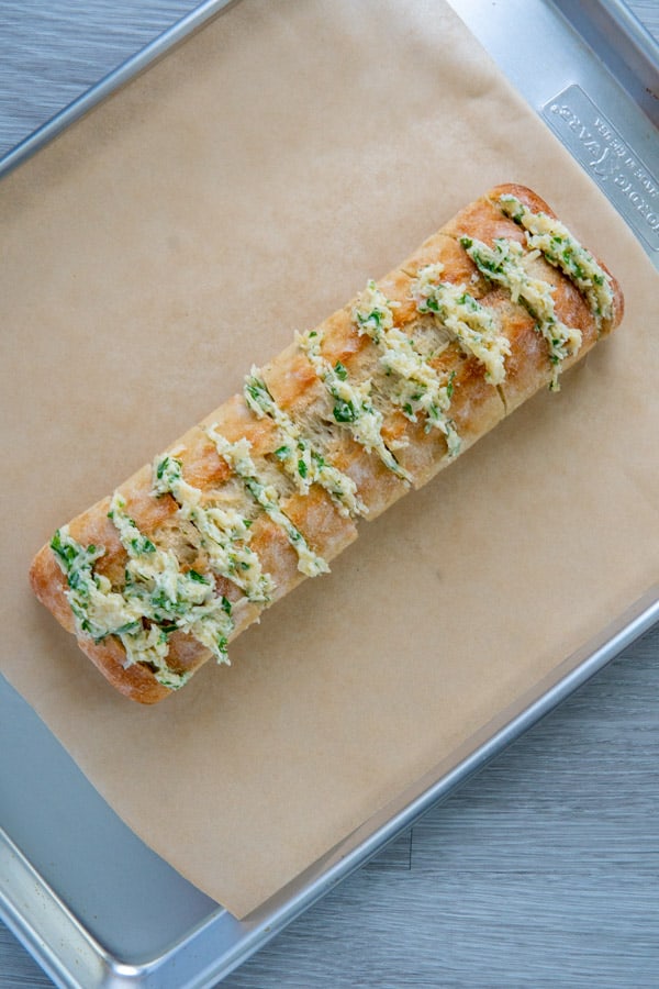 Stuffed garlic bread before baking on a sheet or parchment paper.