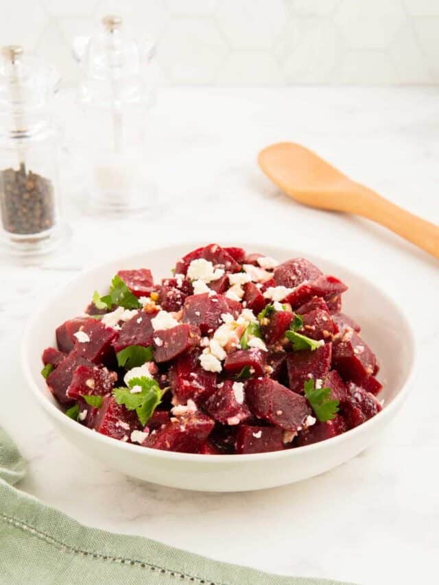 Beetroot and feta salad in a white bowl with a green napkin.