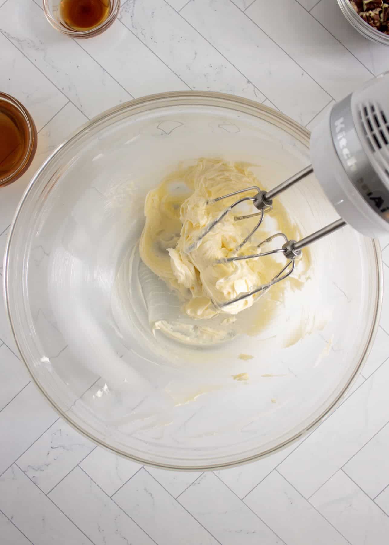 Creaming butter in a glass bowl with a KitchenAid mixer.
