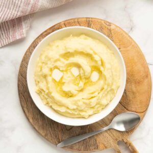 An overhead shot of mashed potatoes with melted butter on top.