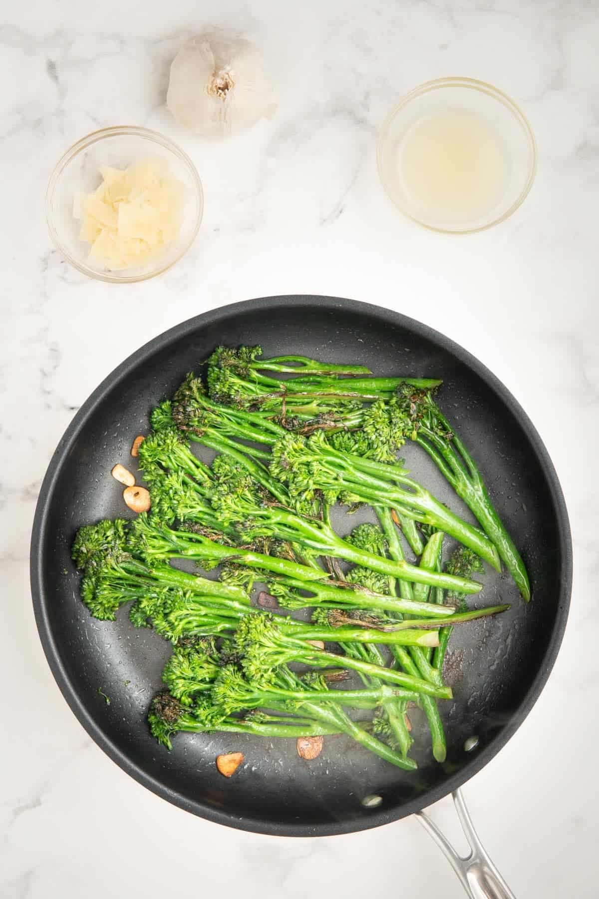 Cooked tenderstem broccoli and garlic in a frying pan.