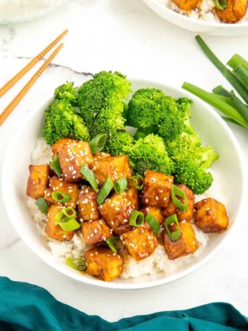 Sticky tofu topped with green onions and sesame seeds.