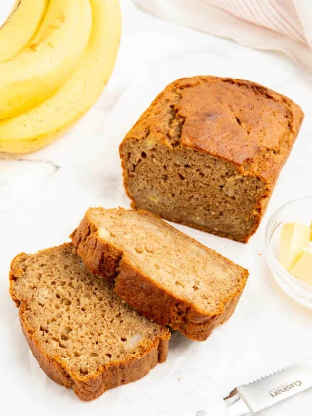 2 slices of 4 ingredient banana bread with whole bananas in the background.