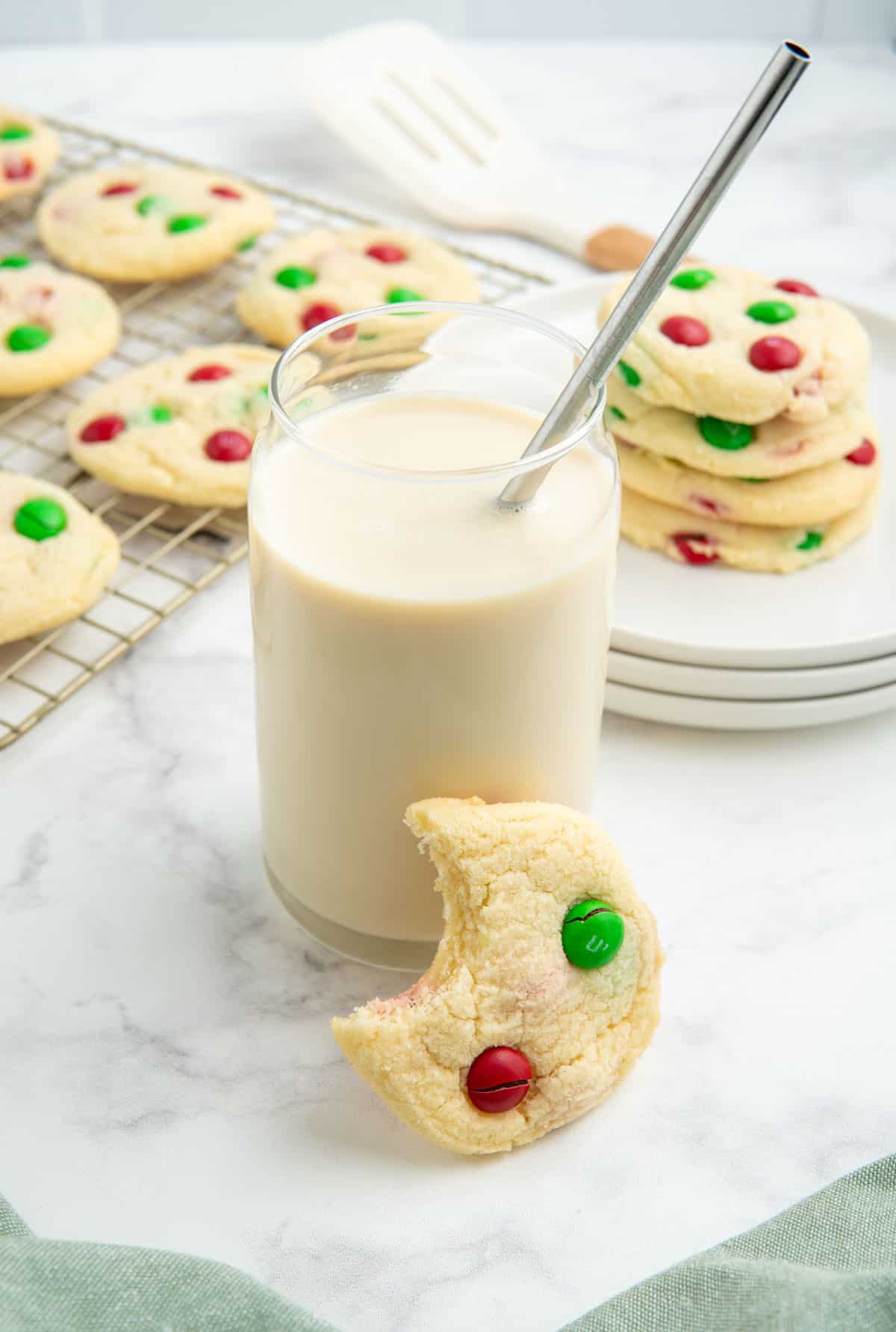 4 Ingredient M&M Christmas sugar cookies with a glass of milk.