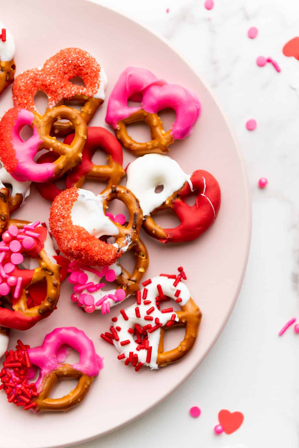 A close up of Valentine's Day pretzels coated in chocolate and sprinkles.