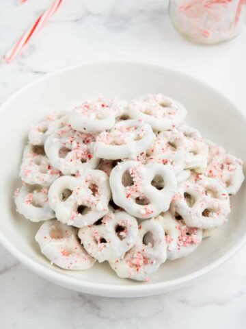 Christmas pretzels stacked in a white bowl.
