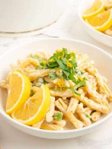 Ricotta and lemon one-pot pasta topped with fresh basil and lemon slices.