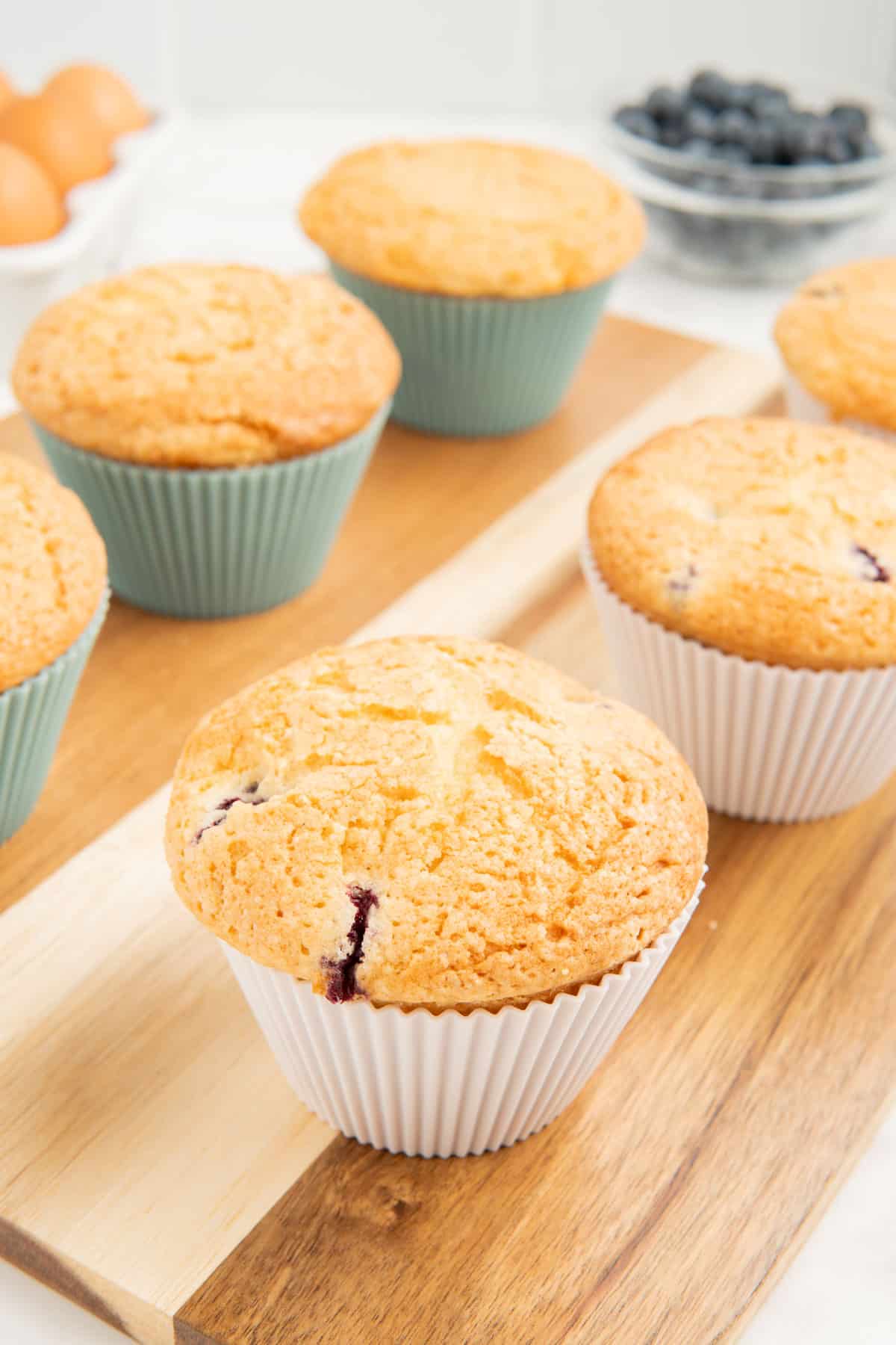 Jumbo blueberry muffins on a wooden board.