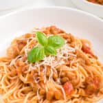 A bowl of 3 ingredient creamy tomato lentil pasta with fresh basil.