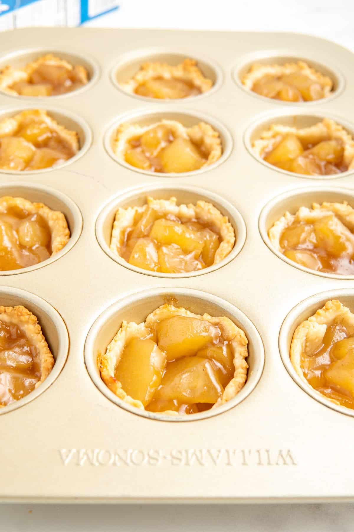 Mini apple pies in a muffin pan.