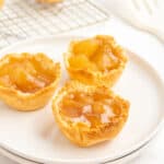 Three mini apple pies on a white plate.