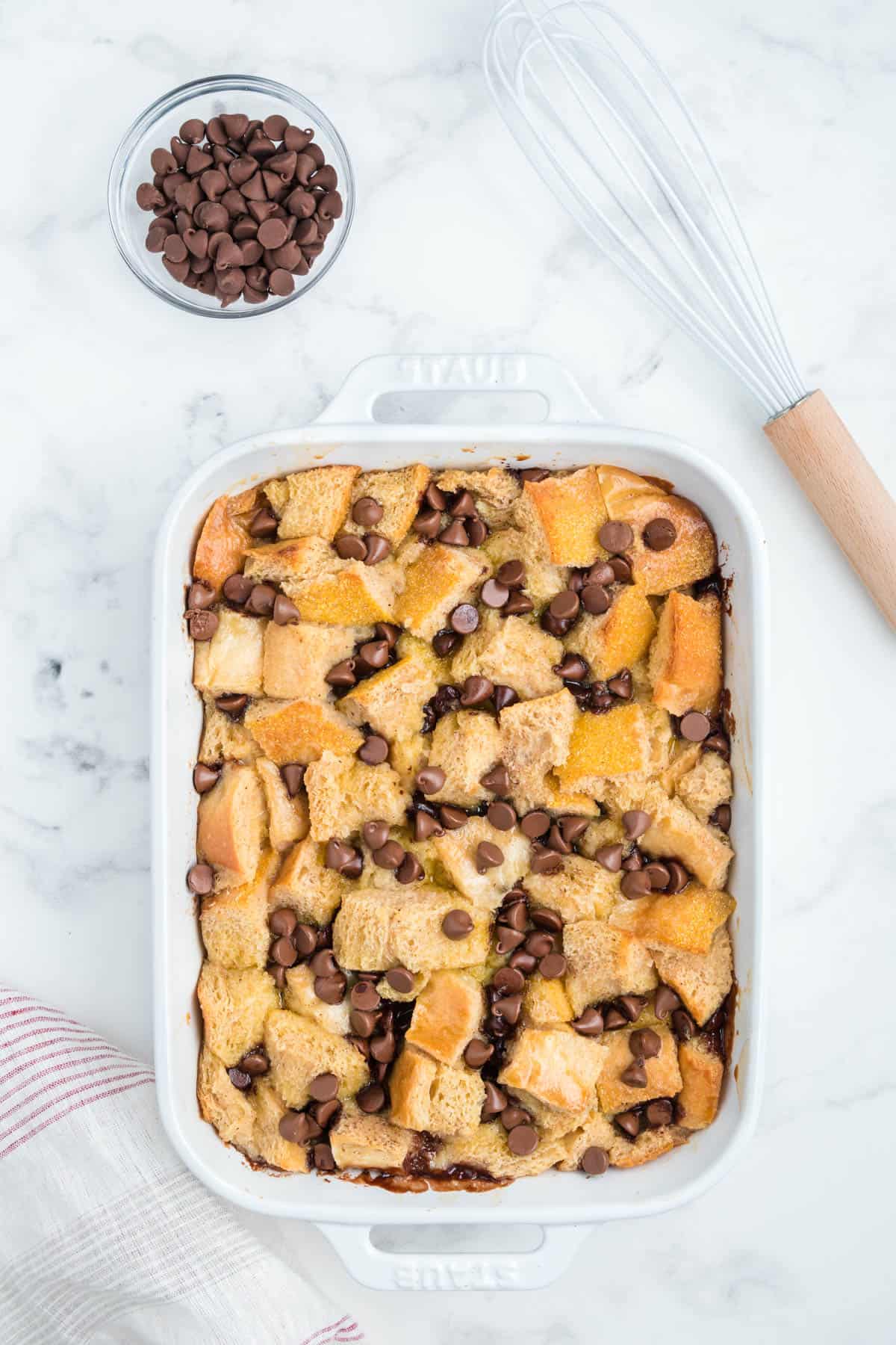 Choc chip bread pudding in a white baking dish.