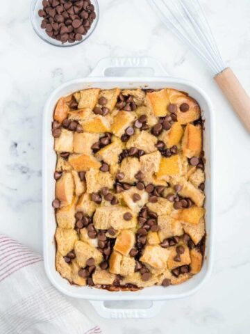 Chocolate chip bread pudding in a white baking dish.