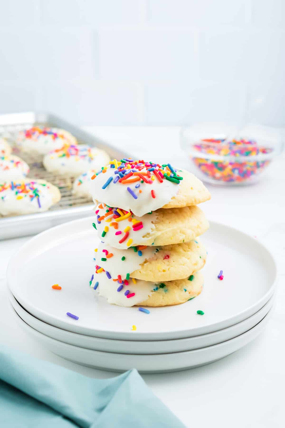 A stack of funfetti cake mix cookies on white plates.