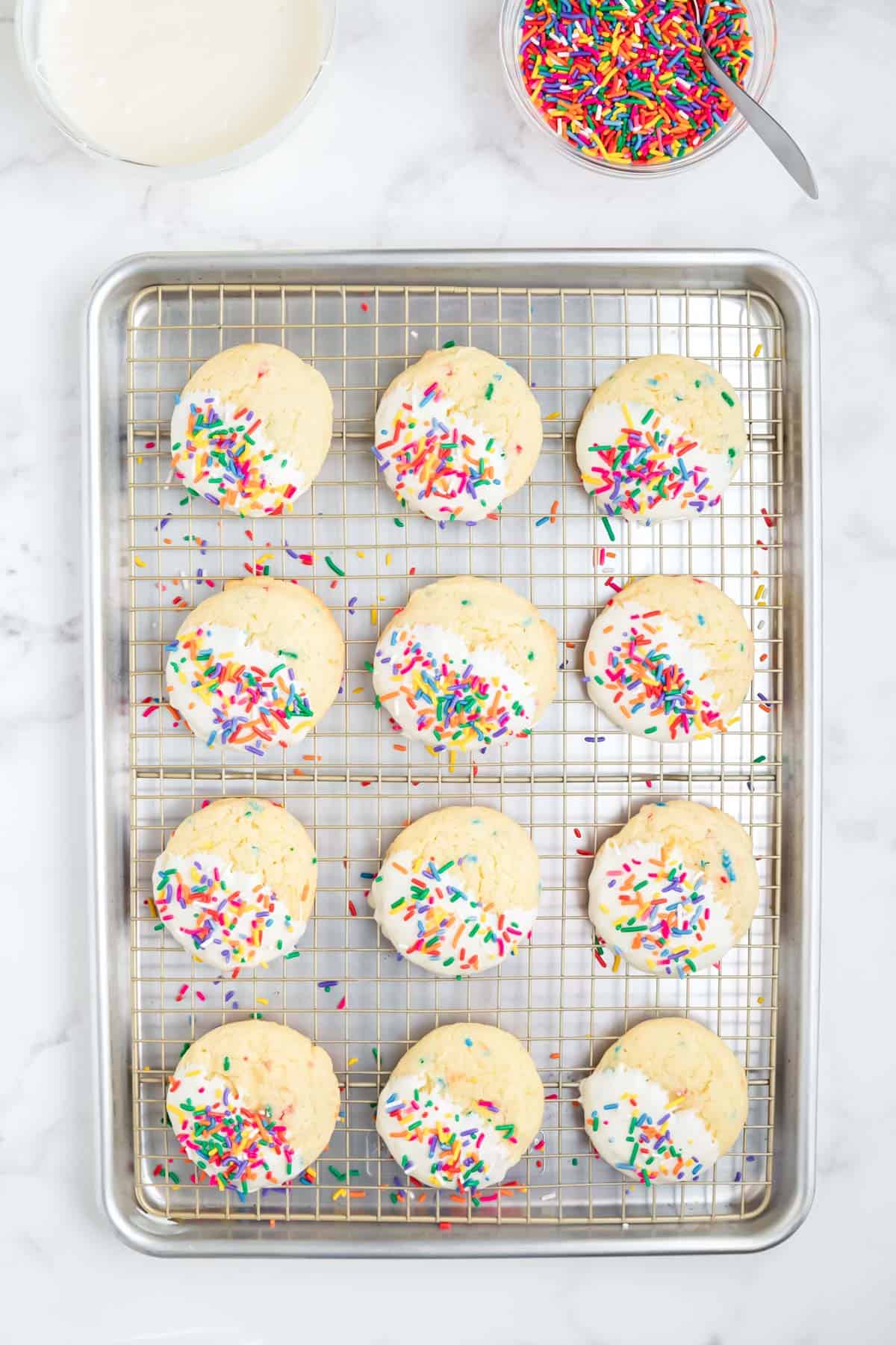 Funfetti cake mix cookies dipped in frosting and covered in rainbow sprinkles.