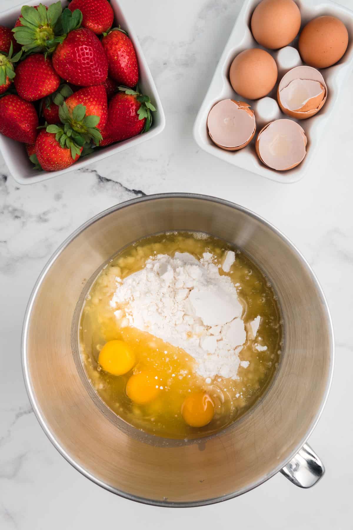 Cake mix, eggs, and oil in a stainless steel mixing bowl.