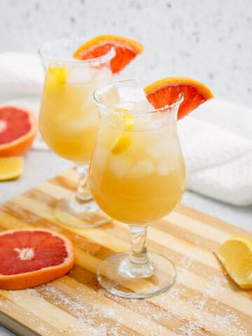 Tequila punch in glasses with salt, lemon, and grapefruit slices.