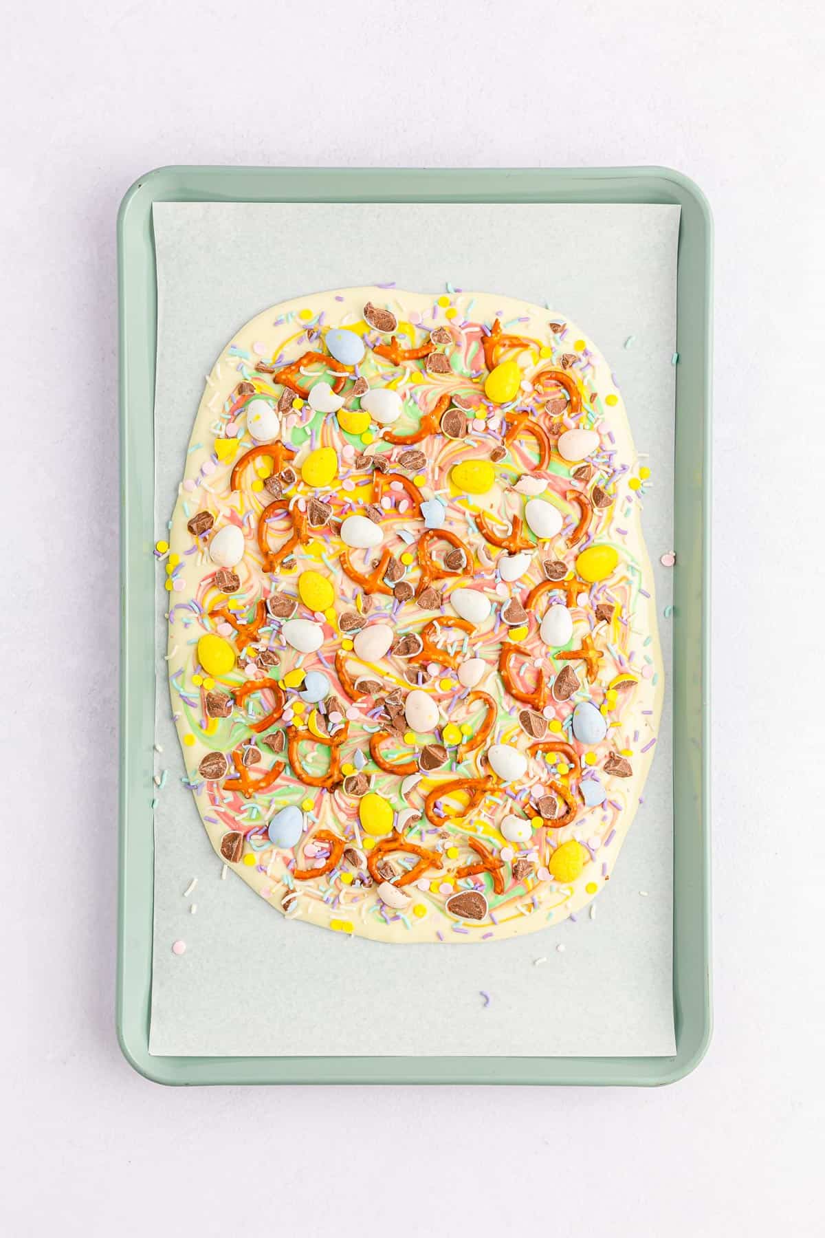 White chocolate topped with mini eggs, pretzels, and sprinkles to make Easter bark.