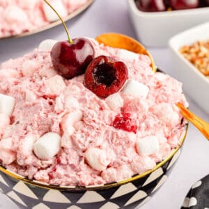 A close-up of cherry fluff salad served with a spoon.
