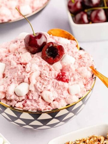 A close-up shot of cherry fluff salad served in a bowl with a spoon.