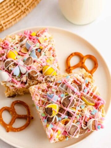 Two squares of mini egg rice krispie treats on a white plate.