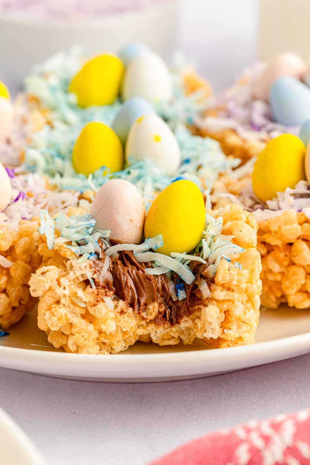 Nutella-filled mini egg rice krispie easter nests on a plate.