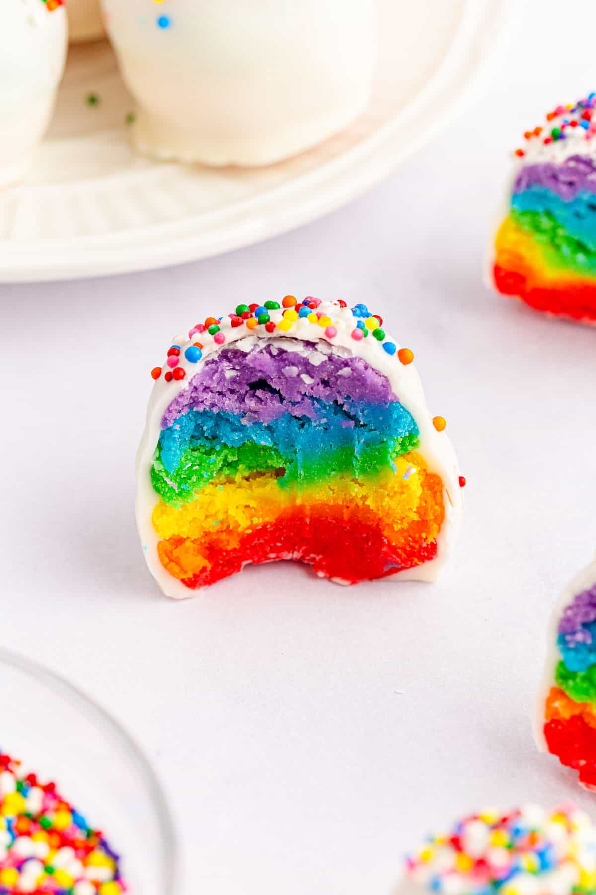 A close-up shot of a no bake rainbow cake ball with sprinkles.