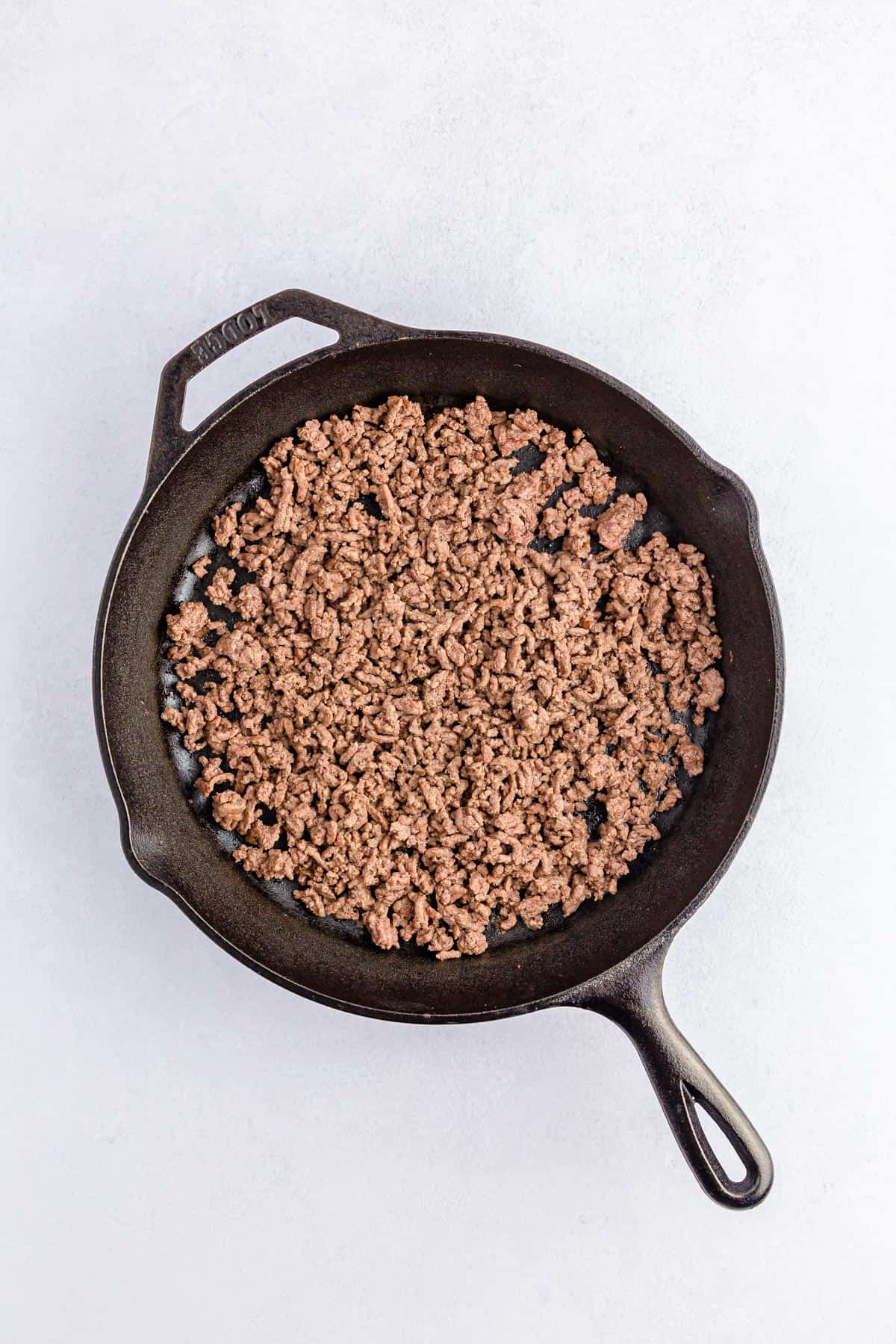 Ground beef for sausage rotel dip browned in a cast iron pan.