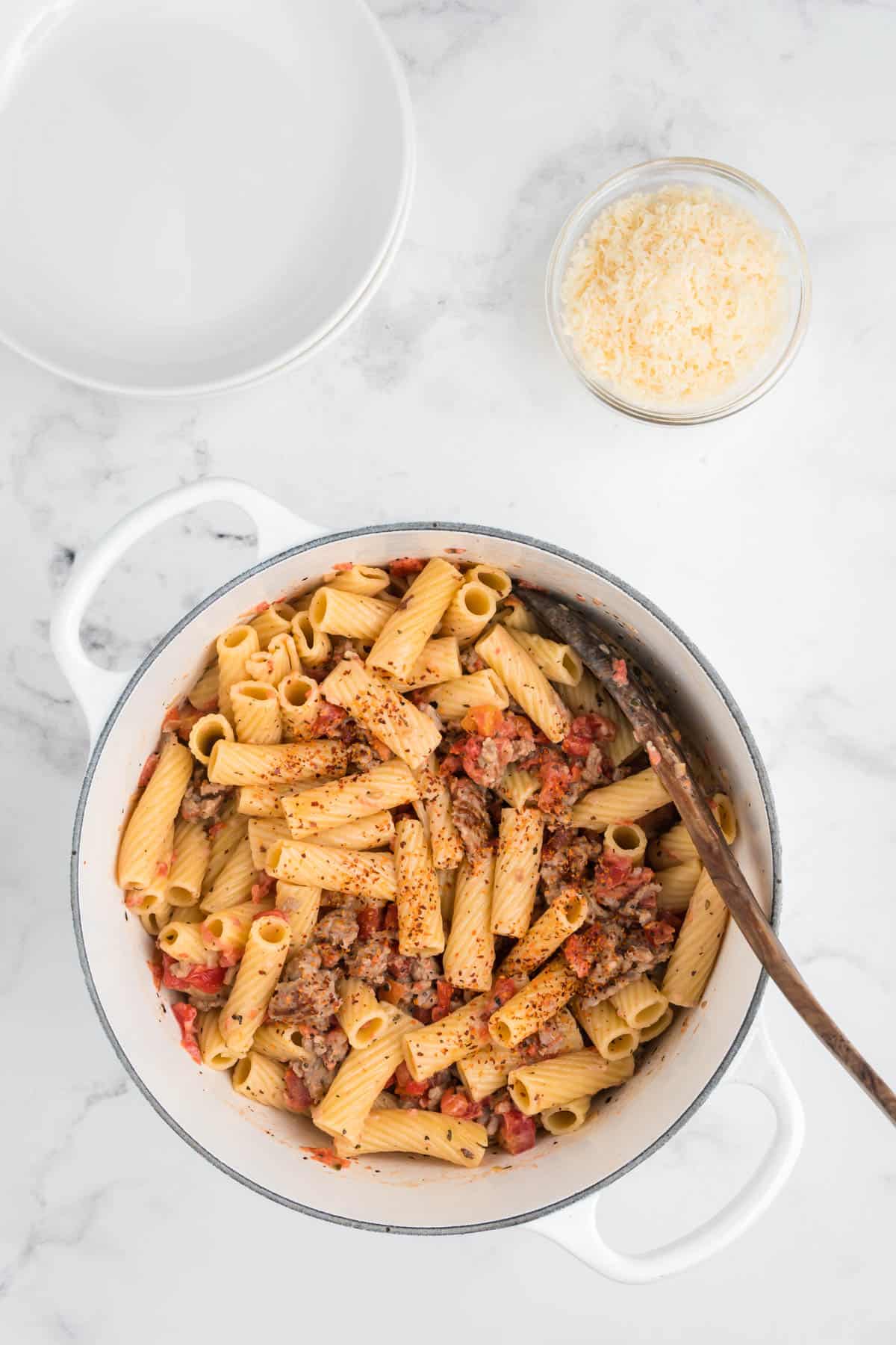 Spicy sausage pasta topped with red pepper flakes.