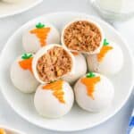 Carrot cake balls on a plate with one ball cut in half.