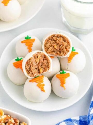 Carrot cake balls on a plate with one ball cut in half.