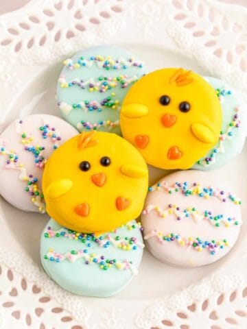 Two yellow chick oreos stacked on blue and pink Easter egg-themed oreos.