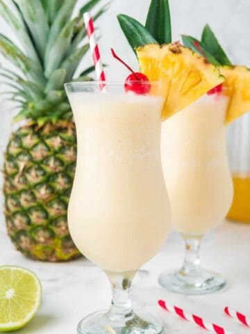 Two pina colada mocktails garnished with pineapple.