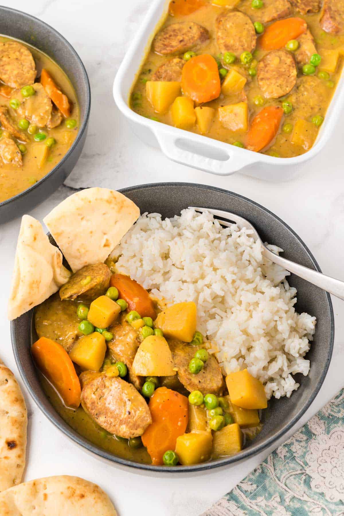 Slow cooker curried sausages in a bowl served with rice.