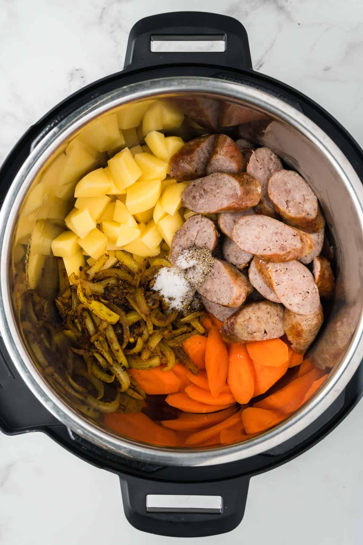 Ingredients for curried sausages added to Instant Pot.