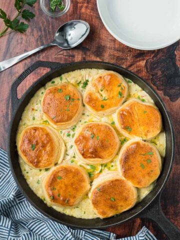 Chicken pot pie with biscuits in a cast iron pan.